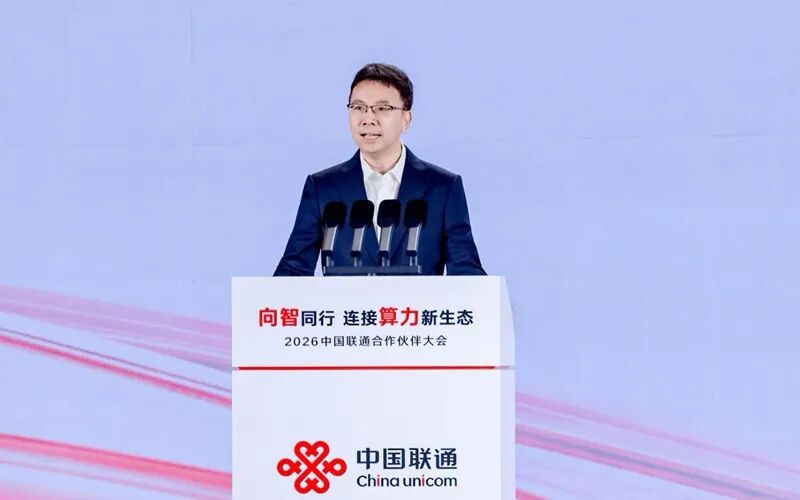 杨超斌在2026中国联通合作伙伴大会讲台发表主题演讲,非机房部署照片。